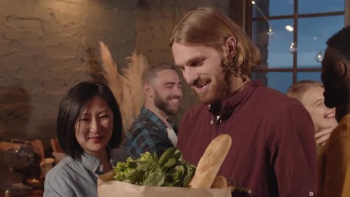 Friends Gather in Kitchen with Groceries and Hugs