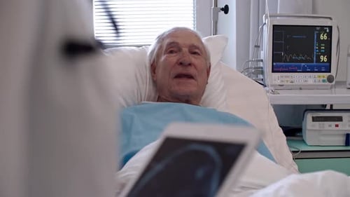 Elderly Man in Hospital Bed with Medical Staff