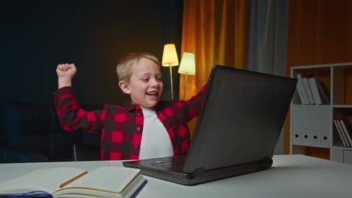 Happy Boy Celebrates Success With Laptop Computer