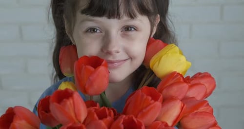 Happy Child Holding Bouquet of Spring Tulips