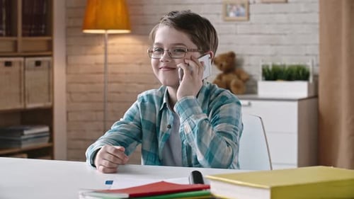 Boy Talking on Cell Phone at Desk Indoors