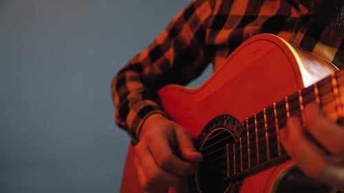 Man Play Acoustic Guitar at Blue Wall