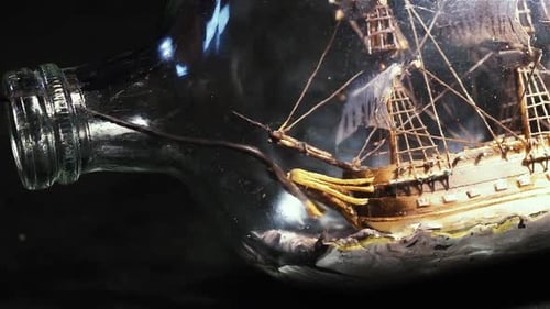 Finishing Touches on Handcrafted Ship in Bottle with Tiny Brush