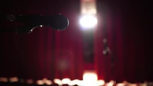 Black Microphone on Stage with Red Curtain Closing