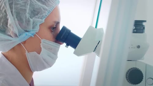 Medical Researcher Working with Microscope in Hospital