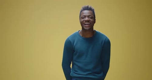 Young Adult Man Waving Against Yellow Background