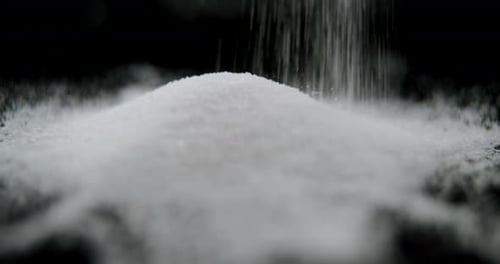 Sugar falling on black background 4k