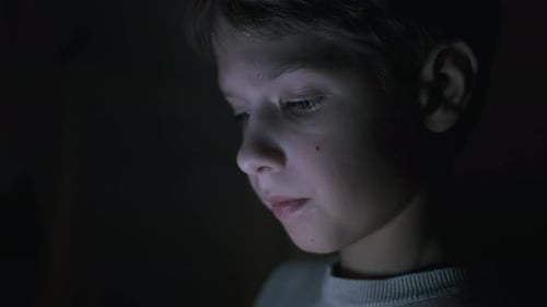 Face Of Boy In The Dark jugando juegos en tableta.