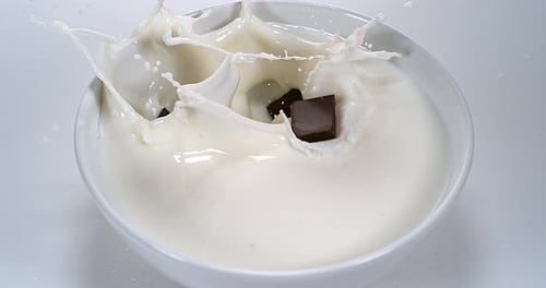 Chocolate Chunks Dropping Into Bowl of Milk
