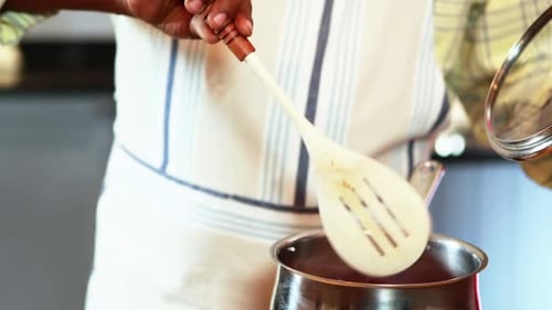 Close Up of Person Stirring Sauce in Pot