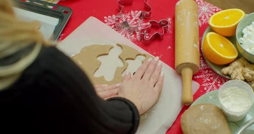 Woman Making Festive Gingerbread Cookies at Table