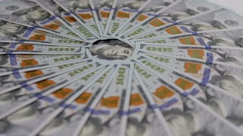 A Closeup of Many Hundreddollar Bills Lie in an Even Circle and Slowly Rotate