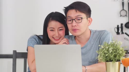 Couple Discussing Something on Laptop at Home
