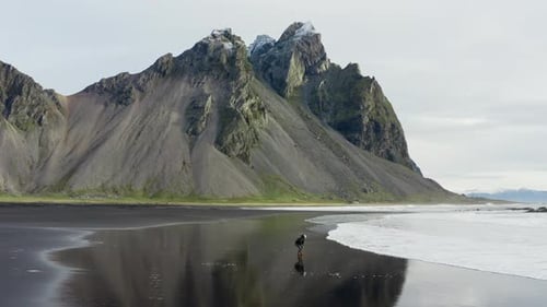 Drone Of Man On Black Beach Under Vestrahorn Mountain