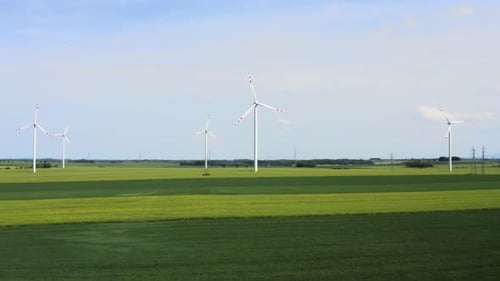 Wind Turbines Rotating in Vast Green Field