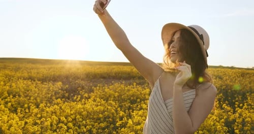 The Smiling Girl Is Holding on To the Hat and Making a Selfie