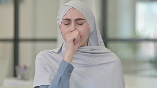 Woman Coughing into Hand in an Office Setting