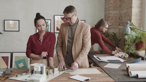 Architects Reviewing Model and Blueprints in Urban Office