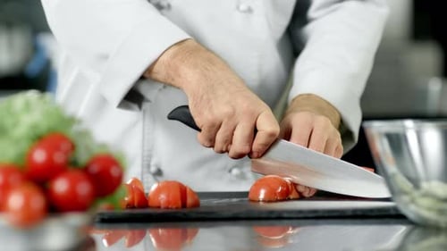 Chef Male Cutting Tomato at Restaurant Kitchen