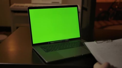 A Man Prepares to Take Notes Learning Online on a Laptop with a Green Screen