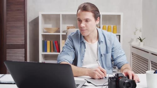Workplace of freelance worker at home office. Young man works using computer.