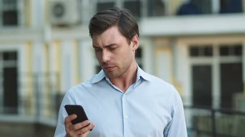 Closeup Man Typing on Phone at Street. Businessman Using Smartphone Outdoors