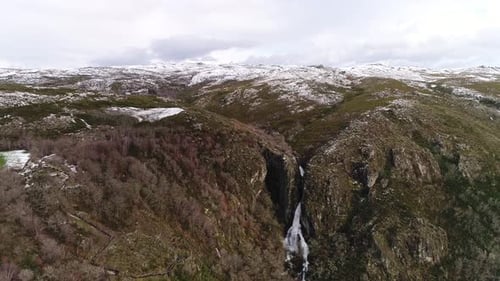 Wasserfall in den Bergen mit Schnee