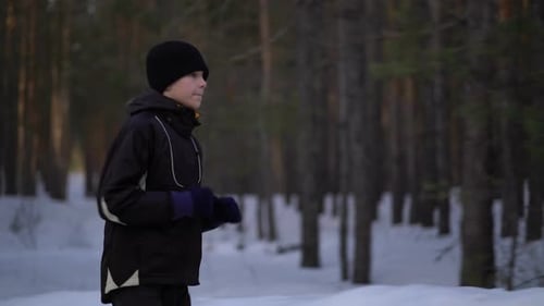 Child Jogging Through Snowy Woods in Winter