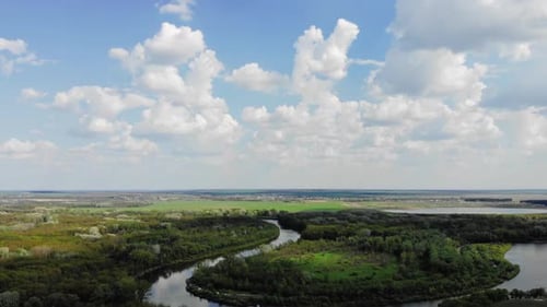 Luftaufnahme Zeitraffer Bewegung von Wolken am blauen Himmel und Wiese und Fluss