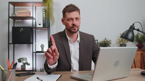 Man at Desk Says No and Types on Laptop