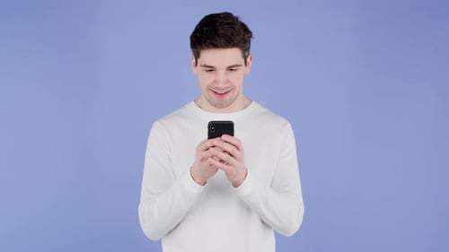 Handsome Man Using Smartphone on Purple Studio Wall