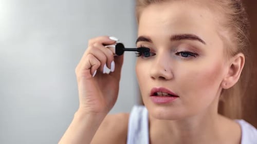 Woman Applies Mascara in Close Up Beauty Shot