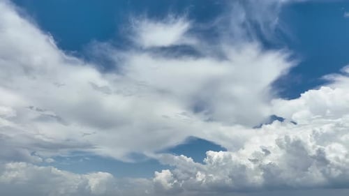 Fluffy White Clouds Float in the Blue Sky