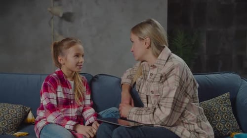 Woman and Child Talking, Using Tablet on Couch