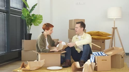 Young Couple Unpacking Boxes in New Home