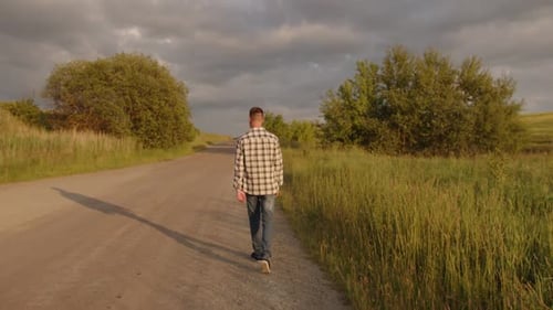 Man Walks Rural Road During Golden Hour
