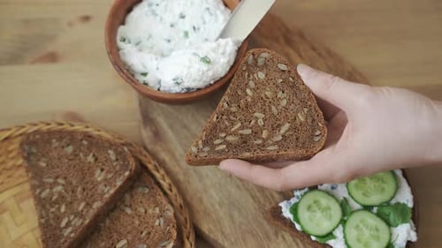 Spreading Cream Cheese on Seeded Grain Bread