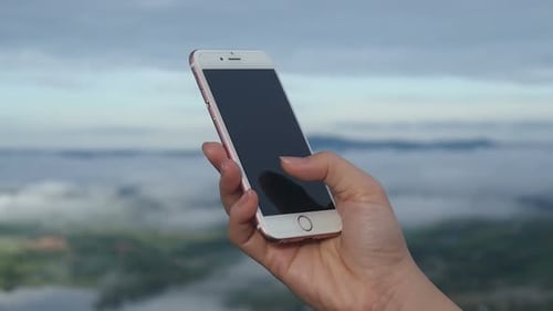 Hand Using Mobile Phone with Nature Background