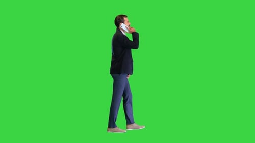 Business Man Walking Forward While Talking on the Phone on a Green Screen Chroma Key