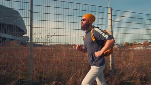Hombre deportivo hipster trotando en la ciudad. Vida activa urbana