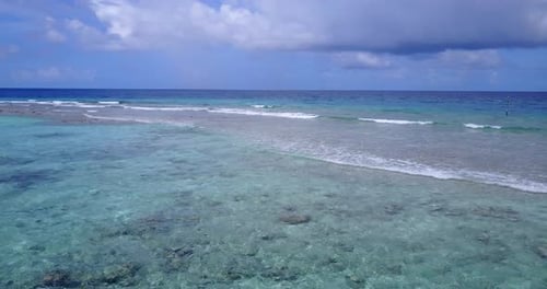 Beautiful above island view of a paradise sunny white sand beach and blue sea background in vibrant