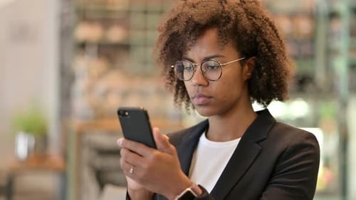 Professional Woman Using Smartphone Device in Office Setting