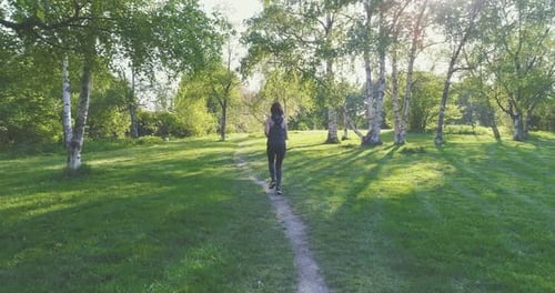 Runner Woman Dressed in Sportwear Running in Park