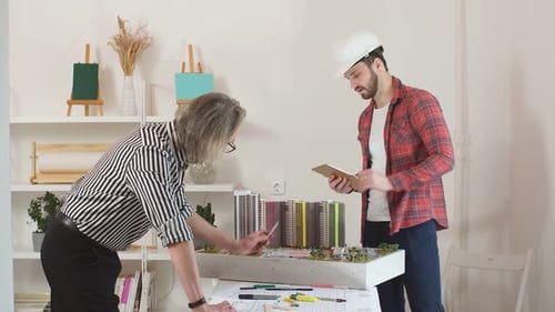 Junger kaukasischer zukünftiger Vorarbeiter und professioneller Architekt arbeiten zusammen.