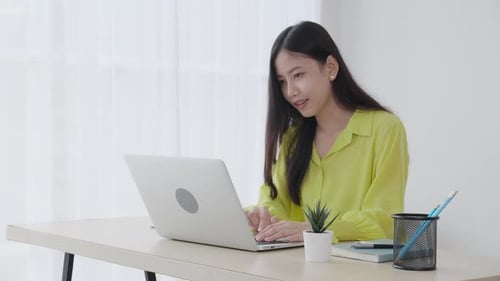 Young asian businesswoman working on laptop computer on desk at home office.