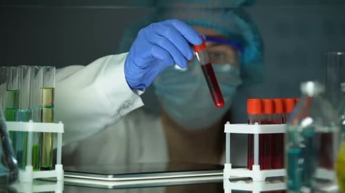 Woman Scientist Analyzes Blood Sample in Lab