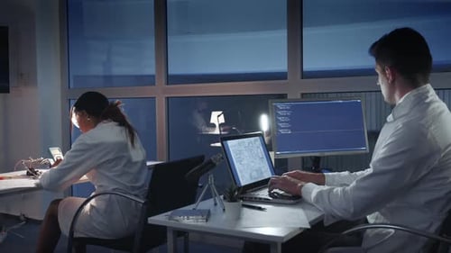 Team von Elektronikingenieuren in weißen Kitteln bei der Arbeit an den Computern im fortgeschrittenen Labor