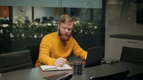 Bearded Male Entrepreneur Using Laptop Computer Working Online In Office