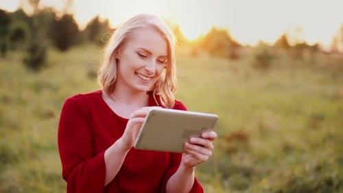 Woman Using Tablet Outdoors During Sunset