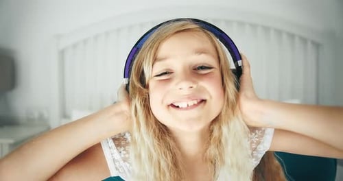 Girl Smiles, Listening to Music With Headphones